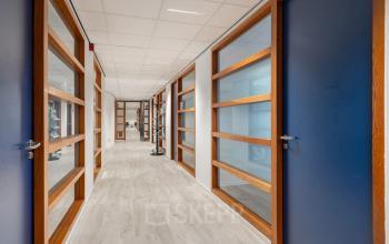Lichte kantoorruimte op A. Hofmanweg 5A in Haarlem Waarderpolder met houten deuren en glazen panelen, ideaal om te huren voor moderne werkplekken.