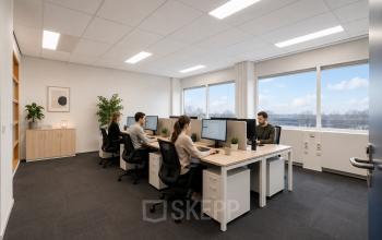 Zakelijk ingerichte kantoorpand met werknemers aan bureaus en uitzicht op Haarlem Waarderpolder. Ideaal voor kantoorruimte huren met alle benodigdheden voor productief werk.