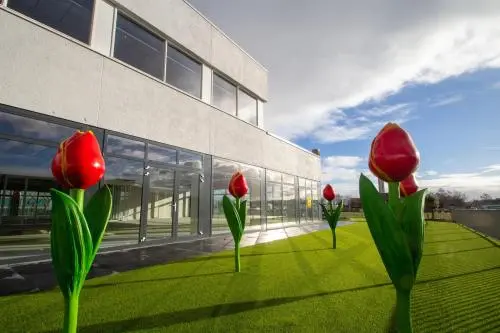 Uitzicht op de buitenzijde van het kantoorpand aan de A. Hofmanweg 5A in Haarlem Waarderpolder met opvallende tulpenkunst op het gazon.