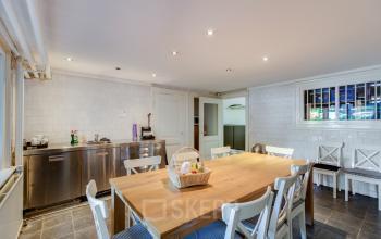 Keuken en eetruimte in het kantoorpand gelegen op Dreef 36, Haarlem Zuid, met houten tafel en witte stoelen, ideaal om kantoorruimte te huren.