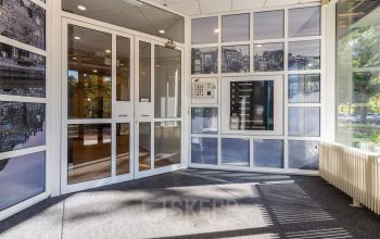 Moderne entree van kantoorpand aan Fonteinlaan 5, Haarlem Zuid met glazen deuren en wegwijzerbord. Ruime en lichte ruimte.