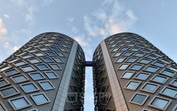 Moderne architectuur van het kantoorpand op Suikersilo Oost-West 1-41 in Halfweg met een blauwe lucht op de achtergrond.