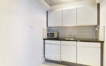 Moderne pantry in een kantoorpand op Suikersilo Oost-West 1-41, Halfweg met strakke kasten en inbouwapparatuur