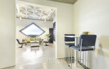 Moderne loungehoek in kantoorpand Suikersilo Oost-West 1-41, Halfweg, met stijlvol meubilair en opvallend raam.