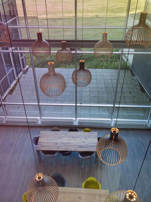 Kantoorruimte huren in Snellius 1, Heerlen; modern ingericht met hoog plafond en grote raampartijen, voorzien van tafels en stoelen.