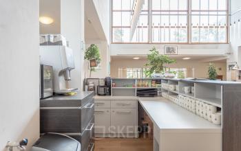 Lichte en uitnodigende pantry in kantoorpand op Oliemolenstraat 60, Heerlen met veel natuurlijk licht en moderne koffievoorzieningen.
