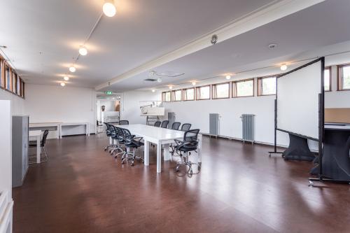 Kantoorpand op Oliemolenstraat 60 in Heerlen, grote ruimte met bureauopstelling, stoelen en projectiescherm.