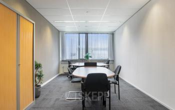Kantoorruimte huren op Jan Tinbergenstraat 202 in Hengelo met een vergadertafel en stoelen, ideaal voor zakelijke besprekingen.