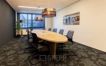 Vergaderruimte in kantoorpand Jan Tinbergenstraat 202, Hengelo met een grote ovale tafel en stoelen, geschikt voor kantoorruimte huren.