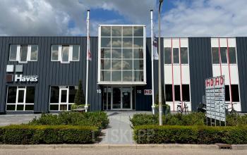 Exterieur van het kantoorpand op Hamerstraat 10 in Hengelo, beschikbaar voor huur. Modern gebouw met opvallende gevel en goed onderhouden omgeving.