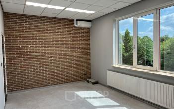 Leeg kantoorpand aan de Hamerstraat 10 in Hengelo met bakstenen muur, grote ramen en veel lichtinval, ideaal voor kantoorruimte huren.