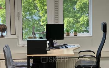 Een lichte kantoorruimte met grote ramen, twee bureaustoelen en een bureau, gelegen op Hamerstraat 10, Hengelo. Geschikt voor kantoorruimte huren.