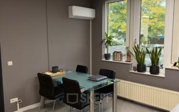 Lichte kantoorruimte op Hamerstraat 10 in Hengelo, met glazen tafel, vijf stoelen en planten voor het raam. Ideaal voor kantoorruimte huren.