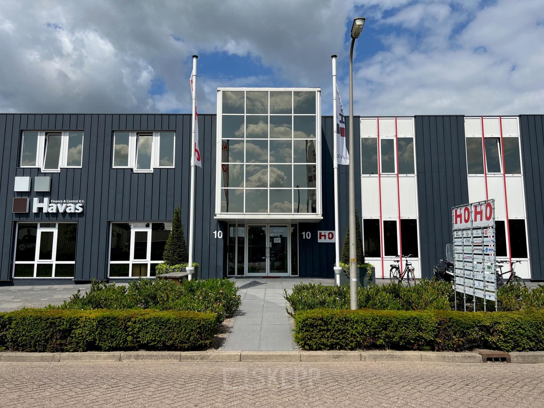 Exterieur van het kantoorpand op Hamerstraat 10 in Hengelo, beschikbaar voor huur. Modern gebouw met opvallende gevel en goed onderhouden omgeving.
