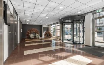 Ingang van het kantoorpand op Demmersweg 21 - 37, Hengelo, met moderne glazen draaideur en zitgedeelte.