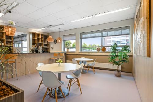 Kantoorruimte huren op Hazenweg 2-2, Hengelo: moderne kantine met eettafels, stoelen en kunstwerken aan de muur.