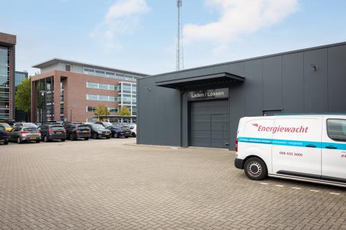 Exterieur van het kantoorpand op Lintelerweg 40 in Hengelo met parkeerplaatsen en een laad- en losruimte.