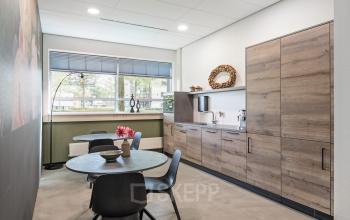 Gemeubileerde keukenruimte in het kantoorpand op Demmersweg 41-47, Hengelo, met moderne meubels en apparatuur.