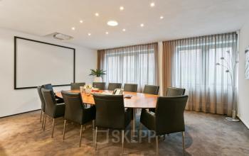 Vergaderruimte in kantoorpand Welbergweg 60, Hengelo, met grote ovale tafel en comfortabele stoelen geschikt voor zakelijke meetings.