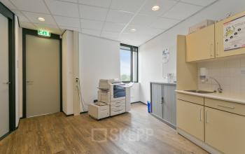 Kantoorruimte met printer en kitchenette op Welbergweg 60 in Hengelo, geschikt voor kantoorruimte huren.