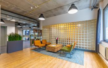Kantoorpand op Mozartlaan 25 in Hilversum met een moderne lounge en kleurrijke stoelen, ideaal om te huren.