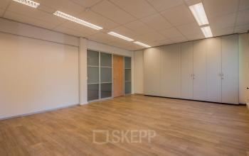 Lege kantoorruimte in het kantoorpand aan de Mozartlaan 25, Hilversum, te huren met een laminaatvloer en inbouwkasten.