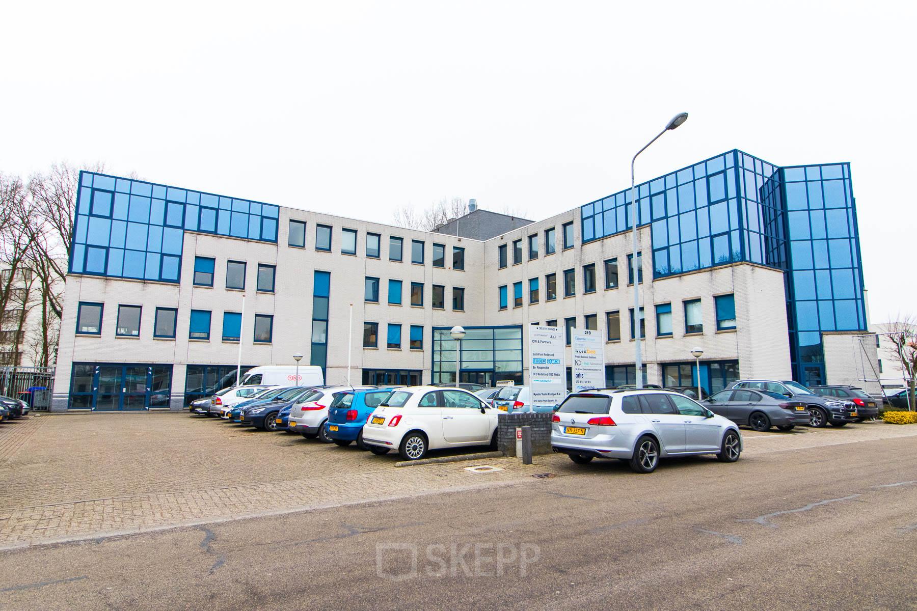 Modern kantoorgebouw aan Franciscusweg 219 in Hilversum met glazen gevels. Ideaal voor bedrijven die kantoorruimte willen huren. Voor het gebouw is er ruime parkeergelegenheid beschikbaar.