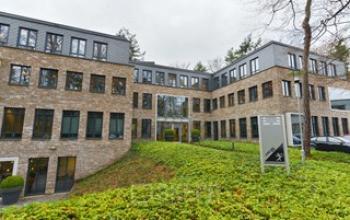 Kantoorpand huren op Catharina van Renneslaan 20, Hilversum. Bakstenen gebouw met meerdere verdiepingen, grote ramen en groene omgeving.