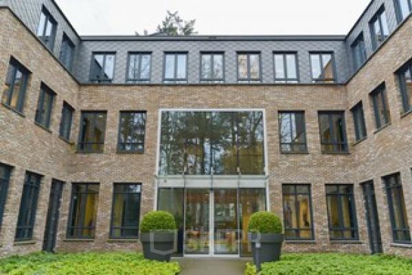 Kantoorpand gelegen aan Catharina van Renneslaan 20 in Hilversum, met bakstenen gevel en grote glazen ingang.