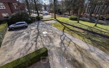 Buitenaanzicht van de parkeerplaats bij Utrechtseweg 47, Hilversum. Ruime parkeerfaciliteiten geschikt voor kantoor gerelateerde activiteiten. Groene omgeving biedt rust voor kantoorpand bezoekers en medewerkers.