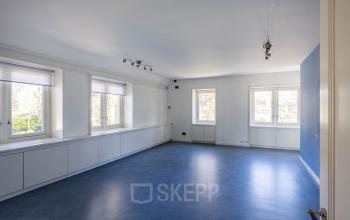 Kantoorruimte huren op Utrechtseweg 47, Hilversum met een ruime, lichte kamer zonder meubilair en grote ramen die veel natuurlijk licht binnenlaten.