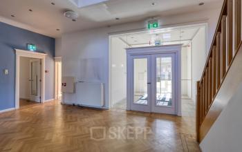 Licht en ruim kantoorpand aan de Utrechtseweg 47 in Hilversum, met houten vloer, witte muren en veel natuurlijk licht. Ideaal voor bedrijven die kantoorruimte willen huren.