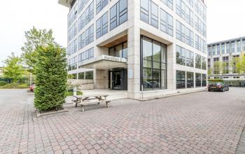 Kantoorpand Marathon 2 in Hilversum met glazen entree en omliggende parkeerruimte, ideaal voor wie kantoorruimte wil huren.