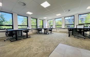 Lichte kantoorruimte in kantoorpand Marathon 2 in Hilversum, geschikt voor huren. De ruimte is modern ingericht met bureaus en stoelen, en wordt verlicht door grote ramen met uitzicht op groen.