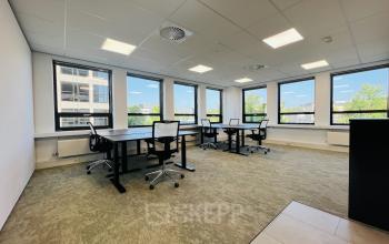 Kantoorruimte te huur op Marathon 2 in Hilversum met uitzicht op de stad, voorzien van bureaus en stoelen, ideaal voor werkplekken.