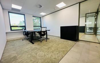 Kantoorruimte met twee bureaus en stoelen, gelegen op Marathon 2 in Hilversum, klaar om te huren. Voorzien van veel natuurlijk licht dankzij grote ramen.