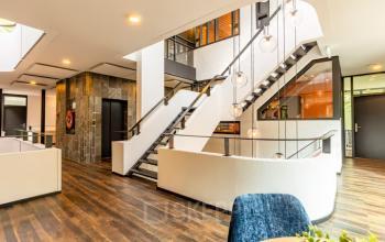 Modern kantoorpand op Steijnlaan 16, Hilversum met een stijlvolle houten vloer en open trap. Ideaal voor het huren van kantoorruimte.