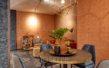 Gezellige kantoorruimte met warme kleuren en stijlvolle meubels op Steijnlaan 16, Hilversum, ideaal voor wie kantoorruimte wil huren.