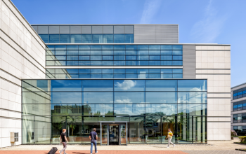 Modern kantoorpand aan Polarisavenue 130-150 in Hoofddorp met glazen gevel, mensen lopen naar de ingang.