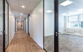 Lichte kantoorruimte huren in kantoorpand Polarisavenue 130-150, Hoofddorp met glazen wanden en houten vloeren.