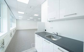 Heldere kantoorruimte met witgeklede muren en een kleine pantry bij Polarisavenue 130-150 in Hoofddorp, ideaal voor kantoorruimte huren.