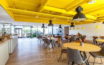Kantoorpand op Polarisavenue 130-150 in Hoofddorp met ruime, moderne werkruimte en frisse, gele plafonddetails, ideaal voor kantoorruimte huren.