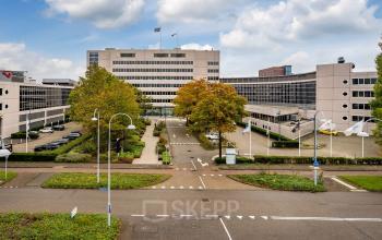 Kantoorpand Polarisavenue 1 in Hoofddorp, omgeving met parkeerplaatsen en groene beplanting.