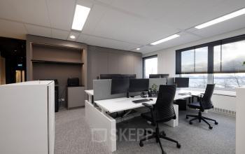 Moderne en functionele kantoorruimte huren op Polarisavenue 1 in Hoofddorp, met bureaus, stoelen en computerschermen, geschikt voor zakelijke activiteiten.