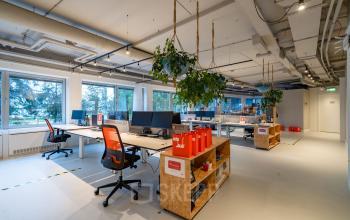 Moderne kantoorruimte huren op Polarisavenue 1, Hoofddorp; ingericht met bureaus, stoelen en groene planten, voorzien van grote ramen voor natuurlijk licht.