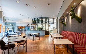 Moderne kantoorruimte huren op Polarisavenue 1, Hoofddorp met kleurrijke inrichting, zitgedeelte en kunstige wanddecoraties.