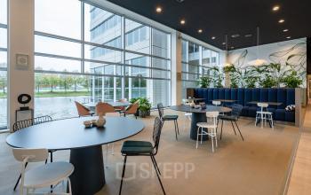 Moderne, lichte kantoorruimte huren op Polarisavenue 1 in Hoofddorp met grote ramen, meerdere zitgedeeltes en stijlvolle inrichting.