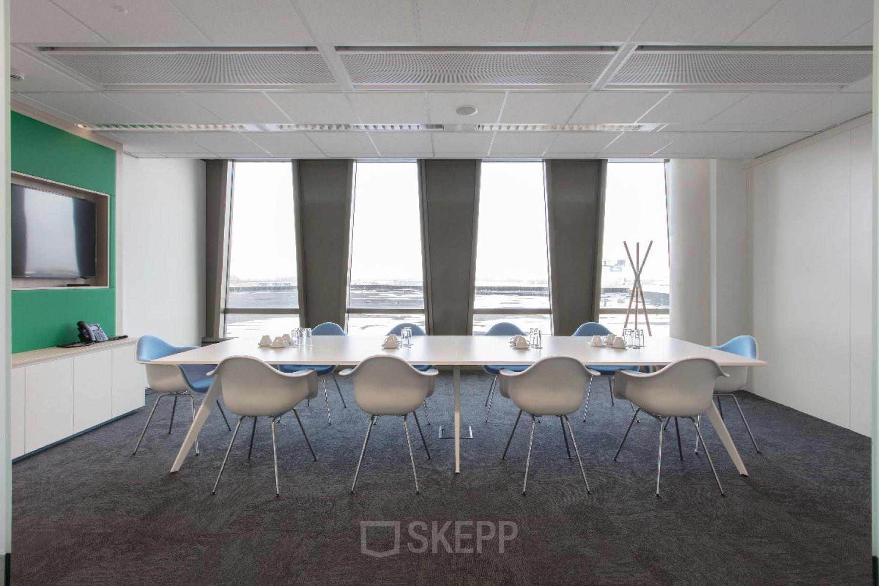 Lichte vergaderruimte in Hoofddorp met lange tafel en moderne stoelen. Gelegen in kantoorpand op Saturnusstraat 40-62. Geschikt voor kantoorruimte huren.