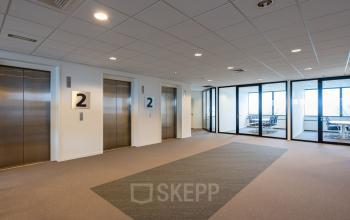 Modern kantoorpand aan de Hoeksteen 54-72 in Hoofddorp met glazen wanden, tapijtvloer en liften. Zakelijke sfeer. Ideale locatie om kantoorruimte te huren.