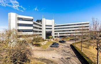 Modern kantoorpand aan de Hoeksteen 54-72 in Hoofddorp met een ruime parkeerplaats en opvallende architectuur.
